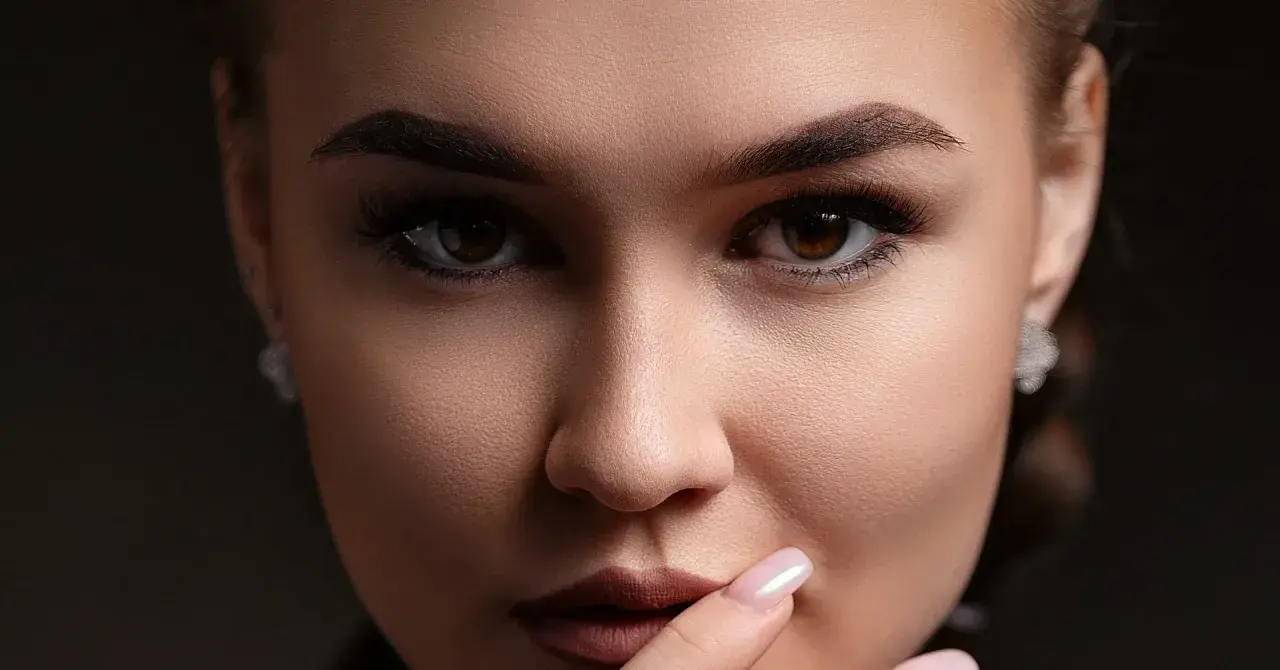 Un gros plan sur le visage d'une femme, ses sourcils parfaitement dessinés après une séance d'épilation.
