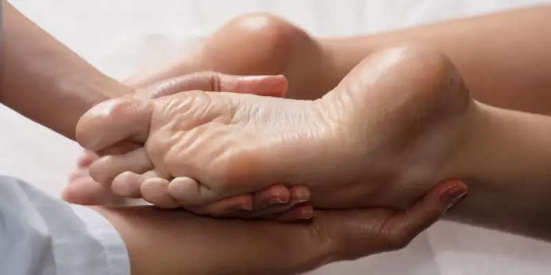 Mains expertes prodiguant un massage relaxant pour une manucure pied parfaite, hydratant et apaisant.